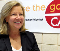 Mary Hughes in front of a Close the Gap CA sign