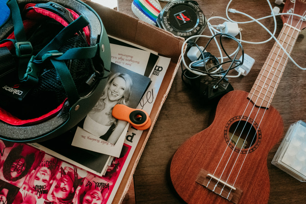 A close-up of a student's items. Most prominent are a ukulele, a helmet and a photo of Kate McKinnon.